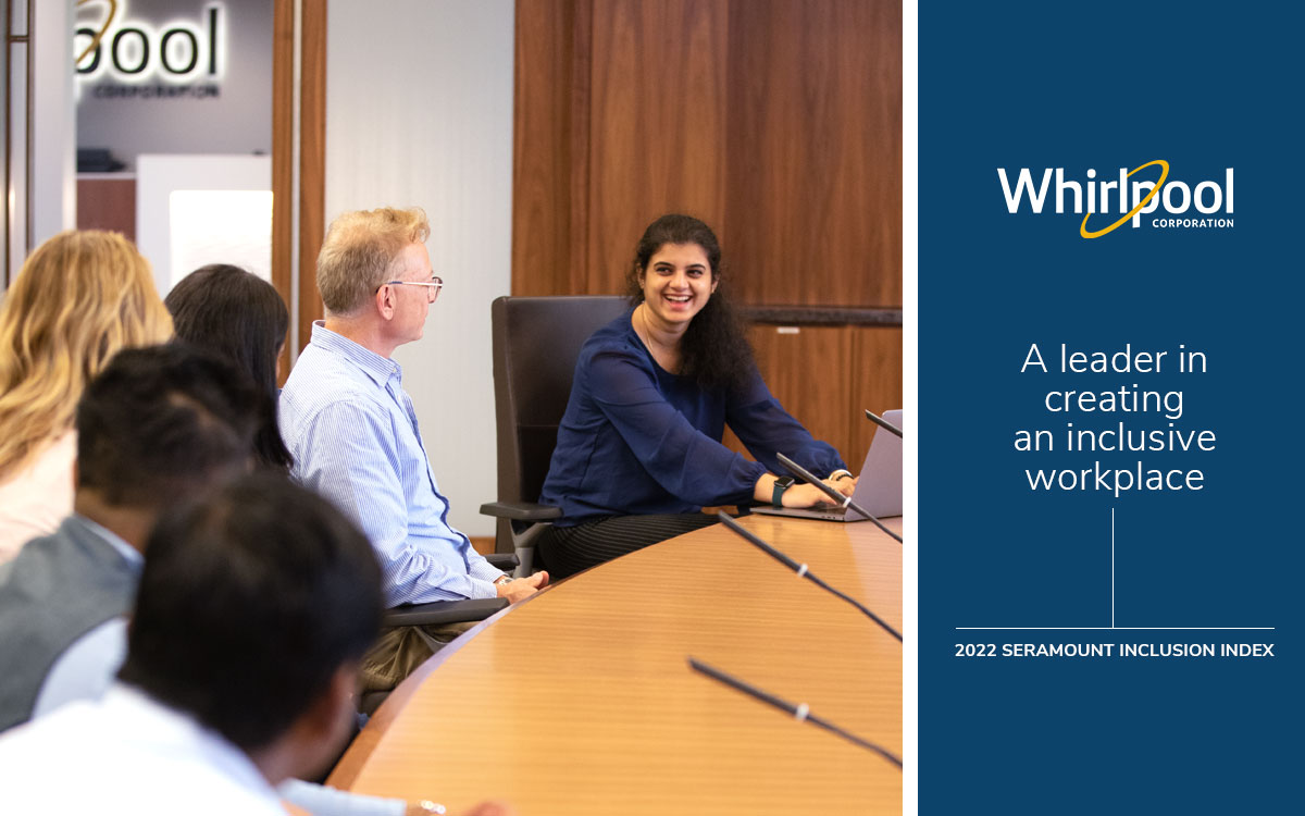 Whirlpool Corporation employees participating in a meeting. Young woman professional is smiling, leading the meeting. Announcement card reads Whirlpool Corp logo, A leader in an inclusive workplace. 2022 Seramount Inclusion Index